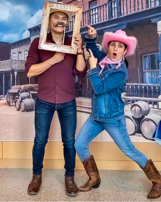ESL student and instructor pose in western wear to celebrate Rodeo Houston.